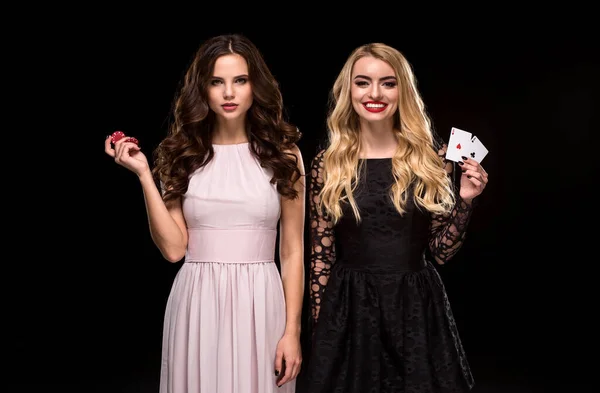 Due ragazze sexy bruna e bionda, in posa con chip nelle sue mani, concetto di poker sfondo nero — Foto Stock