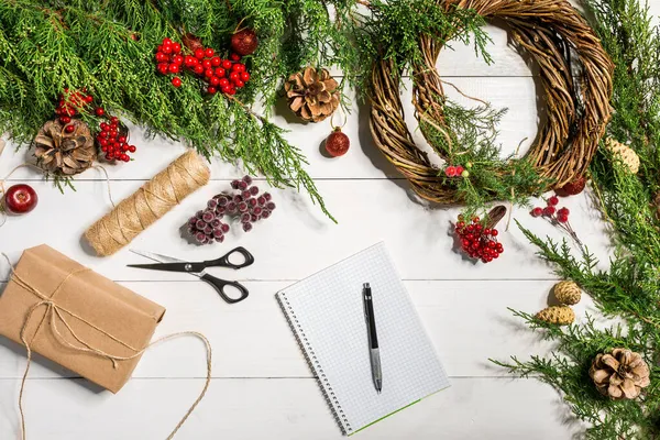 Packad gåvor och rullar, spruce grenar och verktyg på träbord. — Stockfoto