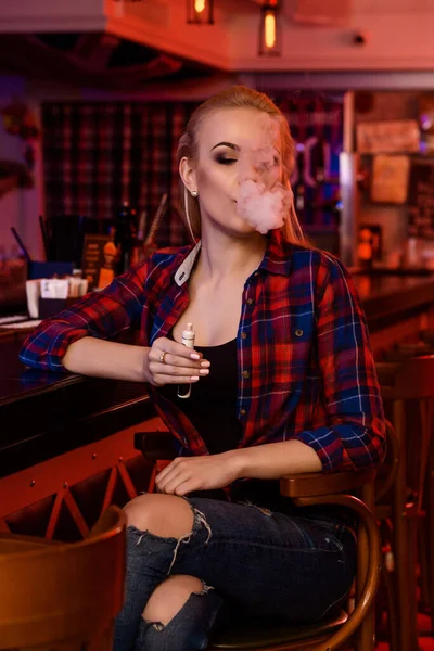 젊고 예쁜 여자가 증기 바에서 전자 담배를 피운다 — 스톡 사진
