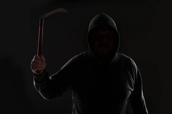 Criminal in dark clothes and balaclava with scythe — Stock Photo, Image