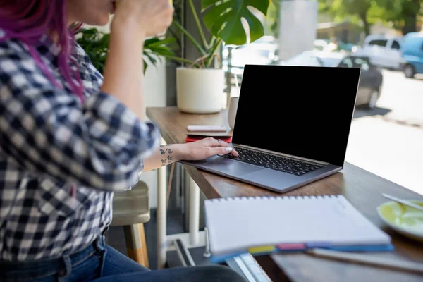 Žena psaní na notebooku s prázdná obrazovka s kopií prostor pro text nebo obsah inzerce, sedící u dřevěného stolu — Stock fotografie