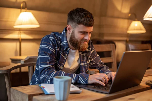 Jungprofi surft im Internet auf seinem Laptop in einem Café — Stockfoto
