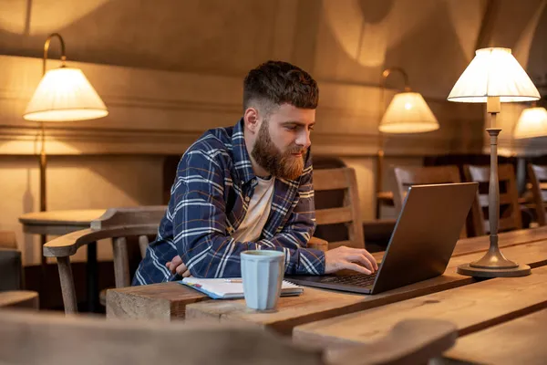 Joven profesional navegando por Internet en su portátil en un café — Foto de Stock