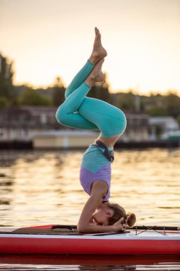 Yoga pozisyonu almış sporcu bir kadın, yemek masasında yoga yapıyor, esneklik ve kas esnekliği için egzersiz yapıyor.
