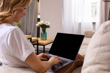 Kadın kanepe üstünde laptop mockup boş bir ekran ile çalışma. Boş kopya alanı monitör reklam için. Siyah ekran.
