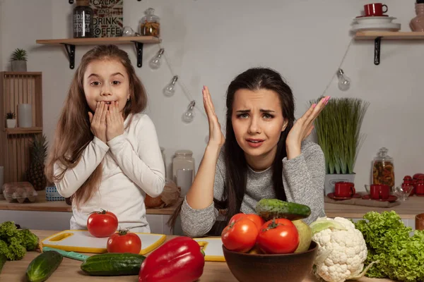 Anne ve kızı sebze salatası yapıyor ve mutfakta eğleniyor.