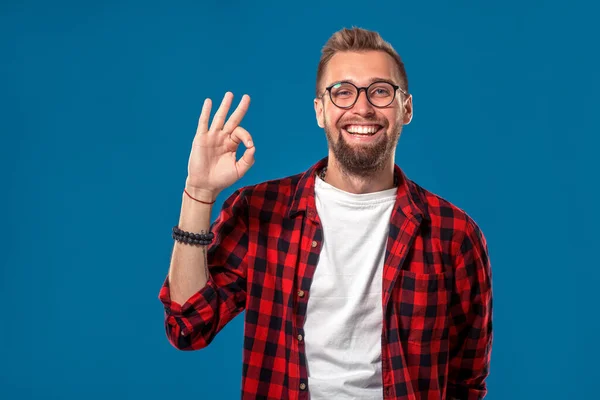 Concepto emocional y de personas: joven barbudo con camisa a cuadros. Estilo Hipster. El tipo muestra su mano - Está bien o bien. —  Fotos de Stock