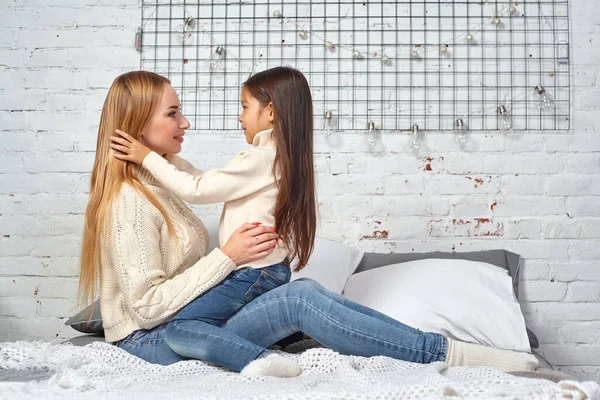 Mãe e sua filha criança menina brincando e abraçando na cama — Fotografia de Stock