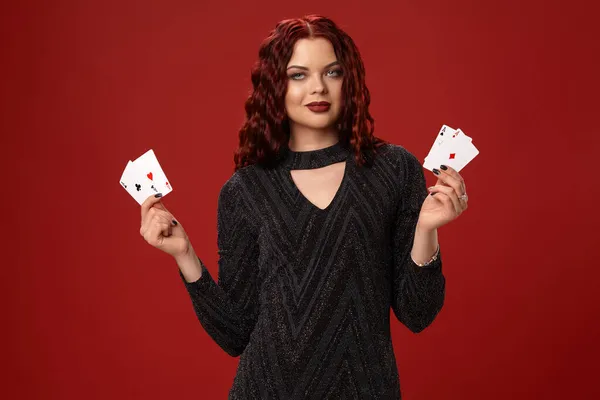 Красивая рыжая женщина держит в руках игральные карты. Казино — стоковое фото