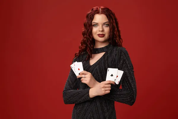 Красивая рыжая женщина держит в руках игральные карты. Казино — стоковое фото