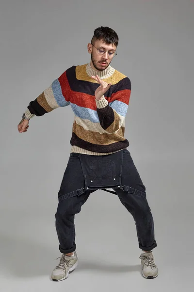Ολόσωμο πορτραίτο ενός αστείου τύπου που χορεύει στο στούντιο σε γκρι φόντο. — Φωτογραφία Αρχείου