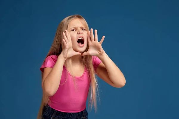 Портрет эмоциональной маленькой девочки на синем фоне — стоковое фото