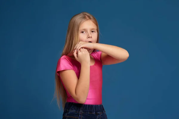 Портрет очаровательной эмоциональной маленькой девочки на синем фоне — стоковое фото