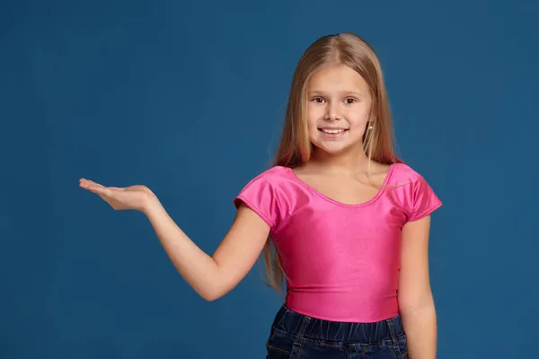 Портрет очаровательной эмоциональной маленькой девочки на синем фоне — стоковое фото
