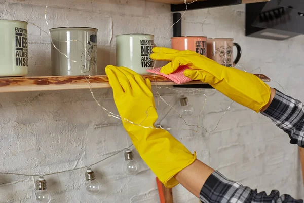 Mulher em luvas de limpeza de móveis com pano em casa cozinha . — Fotografia de Stock