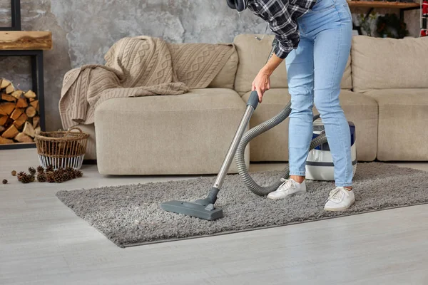 Immagine ritagliata di bella giovane donna che utilizza un aspirapolvere mentre pulisce il tappeto in casa — Foto Stock