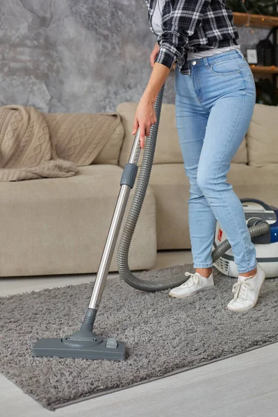 Imagen recortada de una hermosa mujer joven usando una aspiradora mientras limpia la alfombra en la casa — Foto de Stock