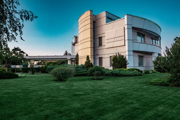 Luxus-Villa umgeben von Rasen mit Pflanzen und Blumen am Sommermorgen — Stockfoto