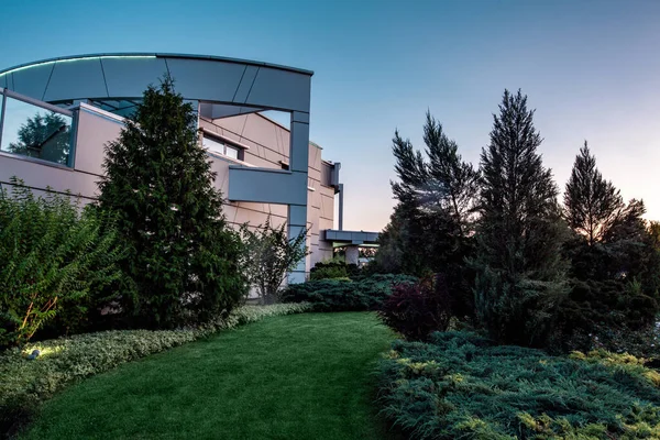 Elegante mansión rodeada de jardín al atardecer de verano — Foto de Stock