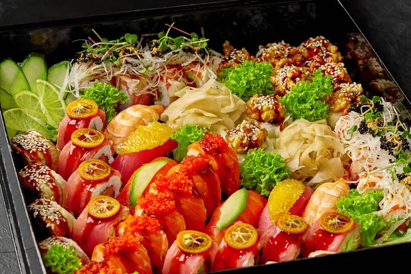 Zbliżenie różnych bułek sushi pakowanych w czarne pudełko tekturowe — Zdjęcie stockowe