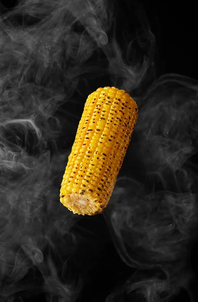 Гриль ухо кукурузы зависает в паре на черном фоне — стоковое фото