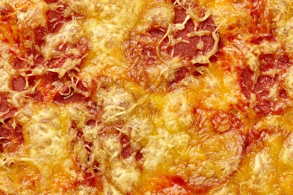 Fechar a crosta de queijo dourado cobrindo fatias de salsicha de soja na pizza vegan — Fotografia de Stock