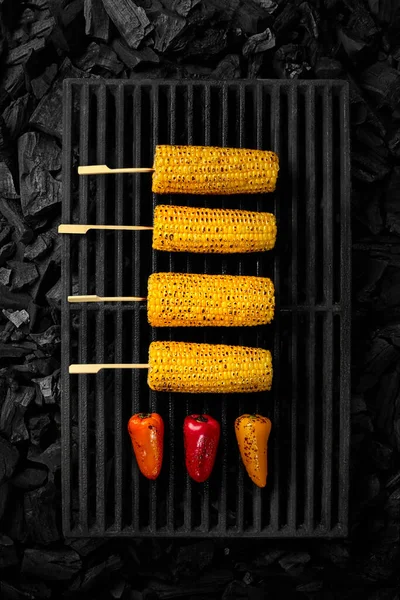 Orelhas grelhadas de milho e pimentão em grelha de churrasco sobre brasas frias — Fotografia de Stock
