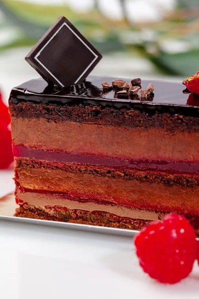 Primer plano de rebanada de pastel con pastel de esponja de chocolate, mousse aireado y confit de frambuesa —  Fotos de Stock