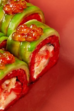 Kırmızı pilav, krem peynir, somon, elma, tobiko, avokado, kırmızı arka planda havyar...