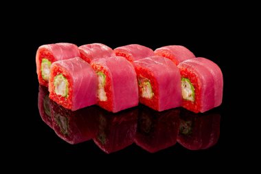 Kırmızı pirinç suşisi omlet, karides, salatalık ve siyah zemin üzerine sarılmış ton balığı.