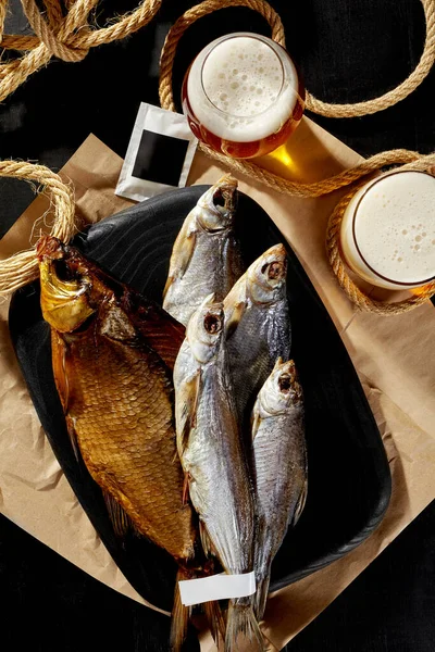 Копченый лещ, соленый сушеный таракан и сабли на деревянной доске с пенным светлым пивом — стоковое фото