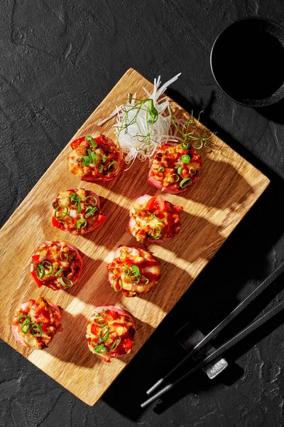 Rouleau de sushi en mamenori aux crevettes cuites au four hachées, tomate, échalotes sur planche de bois — Photo