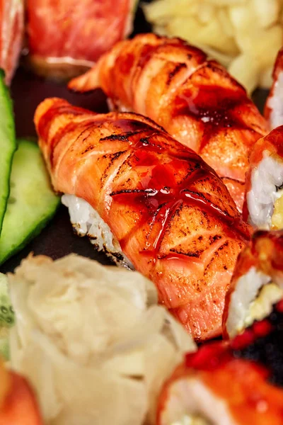 Zbliżenie nigirizushi z przypalonym łososiem i sosem unagi serwowane w zestawie sushi — Zdjęcie stockowe