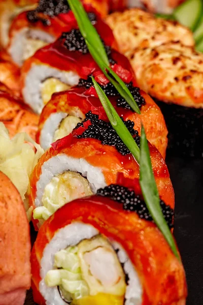Uramaki z krewetek, ogórek, mango, łosoś, czarny tobiko i sosem unagi w zestawie sushi — Zdjęcie stockowe