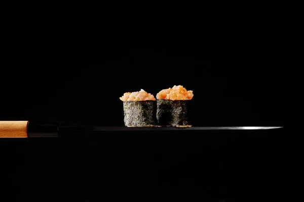 Gunkan maki com cobertura de salmão cru e tobiko vermelho em lâmina fina de faca japonesa — Fotografia de Stock