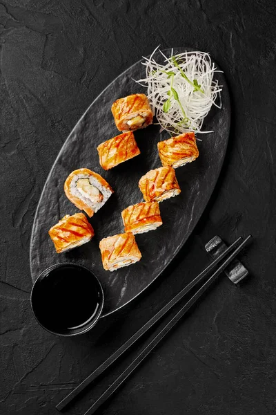 Vue du dessus des rouleaux de sushi au saumon poêlé, fromage à la crème, pomme et tobiko sur ardoise — Photo