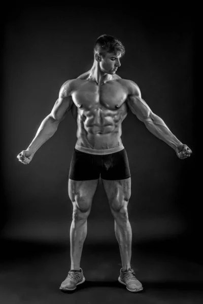 Μυϊκή bodybuilder τύπος κάνει που παρουσιάζουν πάνω από το μαύρο φόντο — Φωτογραφία Αρχείου
