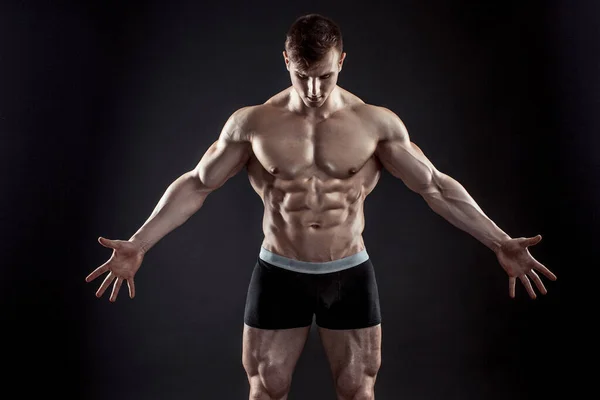 Muscular bodybuilder guy doing posing over black background — Stock Photo, Image