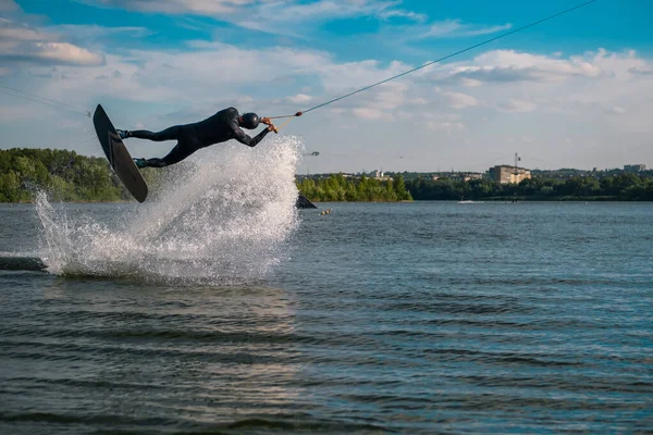 Wakeboarder öva tricks hoppa ombord ovanför vattenytan skapa stänk — Stockfoto