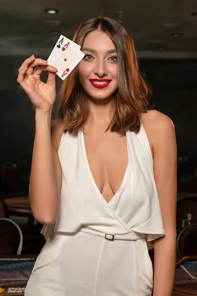 Úspěšná hnědovlasá dívka demonstrující pár es v kasinu — Stock fotografie