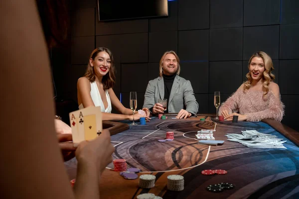 Šťastní dobře oblečení dospělí hrají poker za peníze na přátelské párty — Stock fotografie