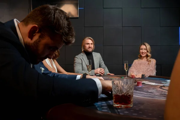 Pozitivní lidé hrají poker u herního stolu v kasinu — Stock fotografie
