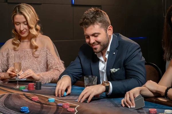 Mladý vousatý muž uzavírá sázky při hraní pokeru v kasinu — Stock fotografie