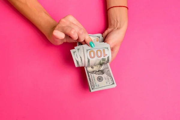 Kobieta trzyma pieniądze w jej ręce. Różowe tło. Widok z góry miejsce. — Zdjęcie stockowe