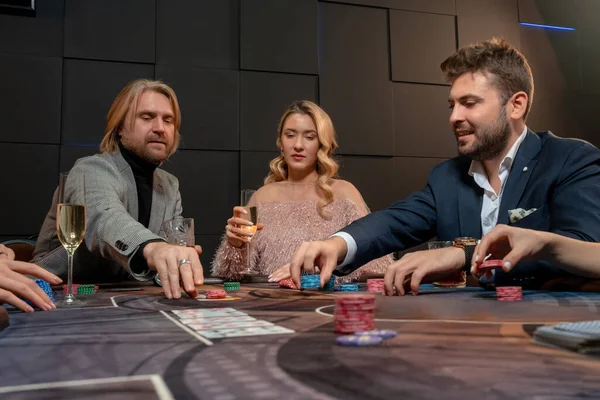 Personas interesadas en beber alcohol y hacer apuestas mientras juegan al póquer — Foto de Stock