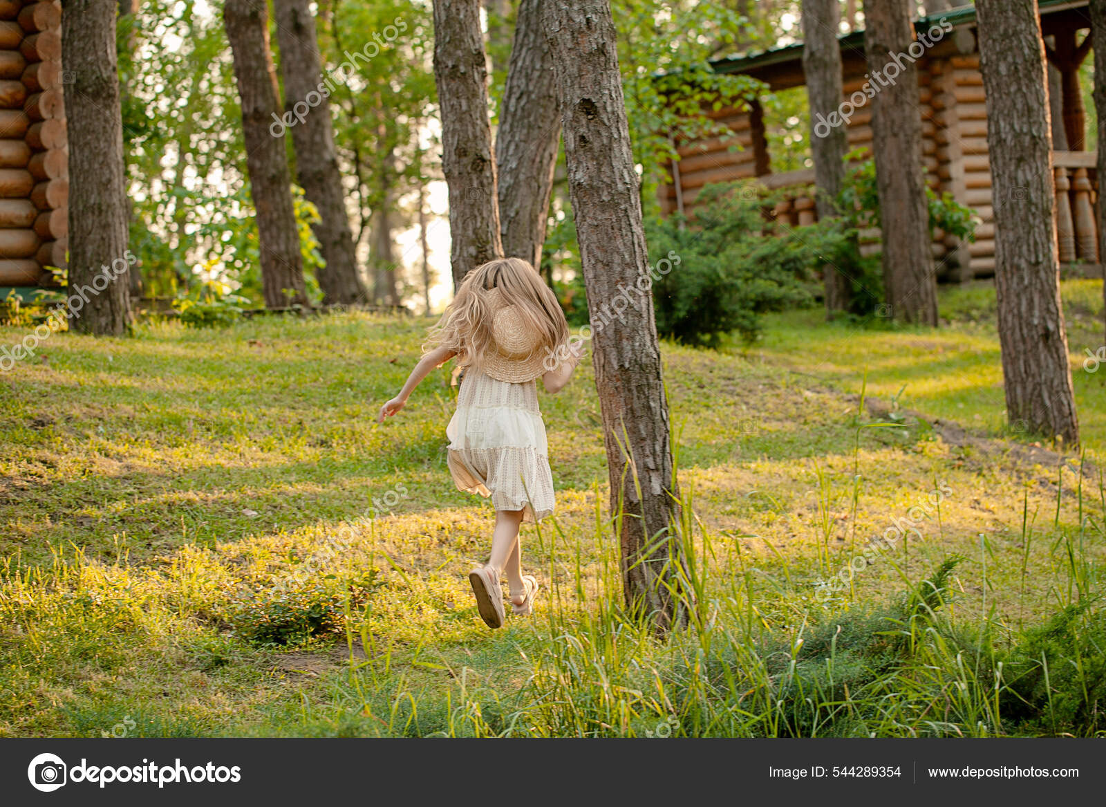 Vista trasera de la niña preadolescente corriendo en el parque verde de ...