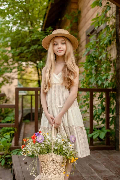 Tween lány kosár színes vadvirágok élvezi nyaralás vidéki birtok — Stock Fotó