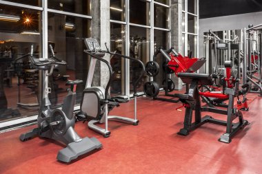 Geniş, aydınlık, içi boş spor salonunda, pencerenin yanında fiziksel eğitim için çeşitli özel ekipmanlar. Modern egzersiz makineleri. Spor, fitnes
