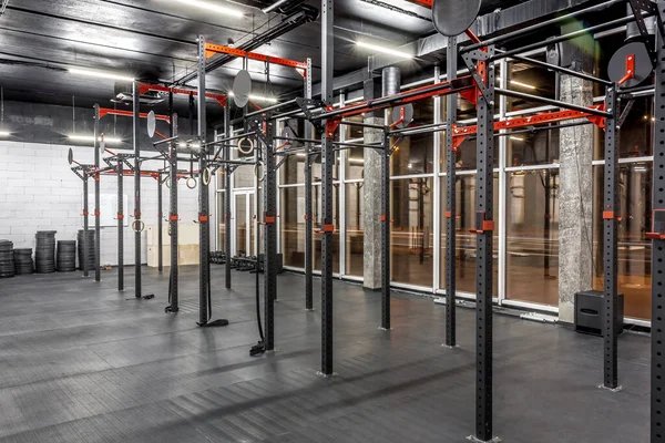 Ginásio de treino para crossfit com interior moderno. Equipamento especial à janela no quarto espaçoso. Barras horizontais, anéis de ginástica. Desporto, fitness — Fotografia de Stock