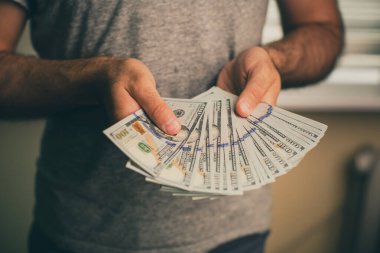 Bir adam dolar elinde tutar.